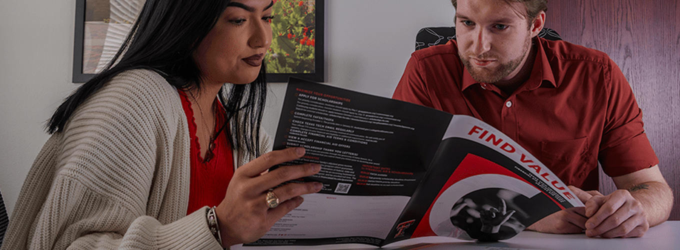 Two people look over TTU college information.
